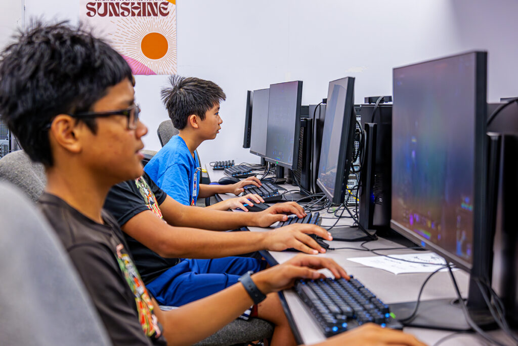 Three students in a computer lab on computers