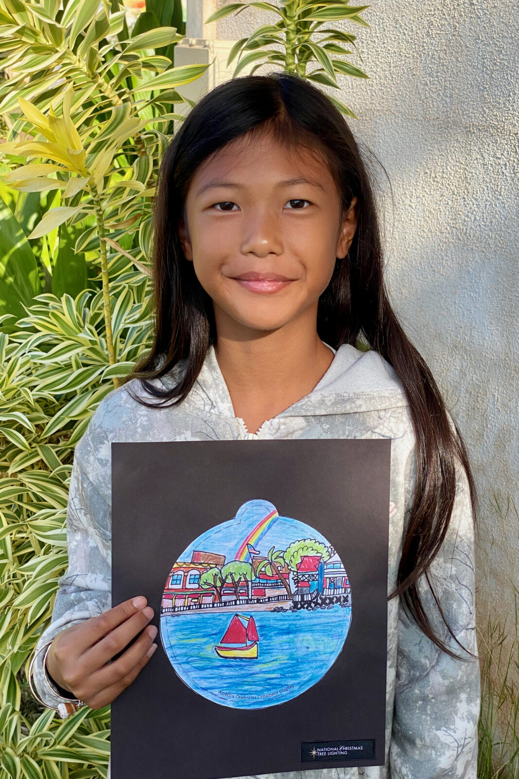 Photo of a Princess Nāhiʻenaʻena Elementary student with her ornament design for the 2025 National Christmas Tree Lighting.