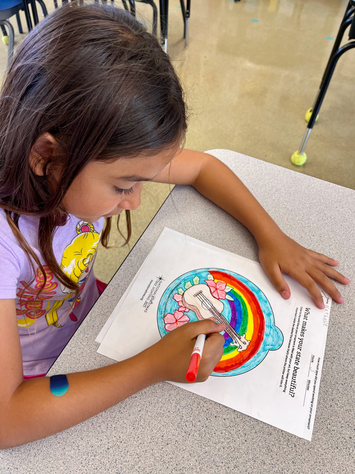 Photo of a Princess Nāhiʻenaʻena Elementary student creating an ornament designs for the 2025 National Christmas Tree Lighting.