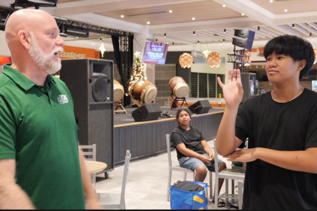 Student signs to his teacher at the Inclusive Santas event