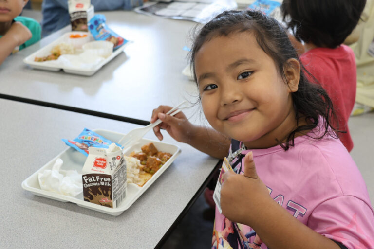 Student smiling and giving a thumbs up to the camera