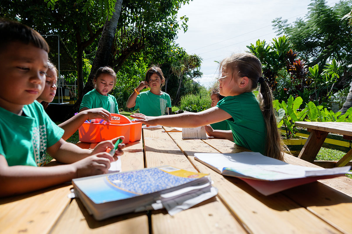 Nānākuli Elementary School students gather around a table for an activity.