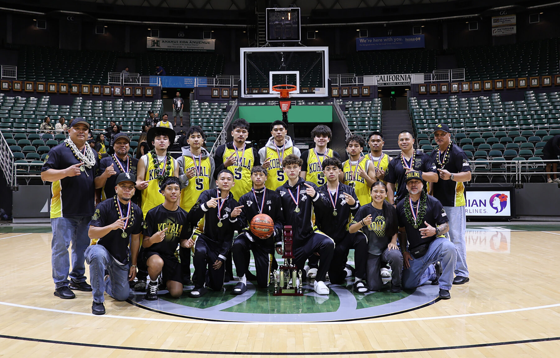 The Kohala boys basketball team with the championship trophy after winning the Division II state title.