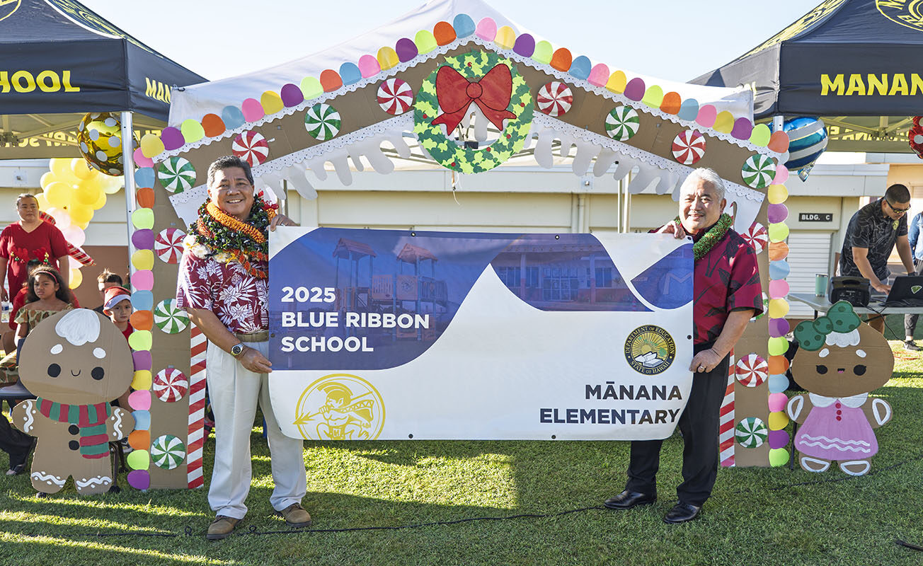 Mānana Elementary School principal and Superintendent Keith Hayashi hold up the 2025 Blue Ribbon School award banner.
