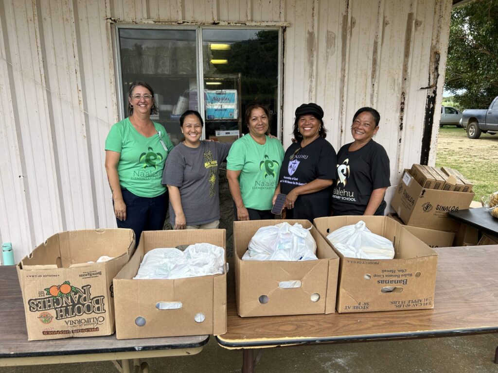 Staff members wait for students to delivery food bags.