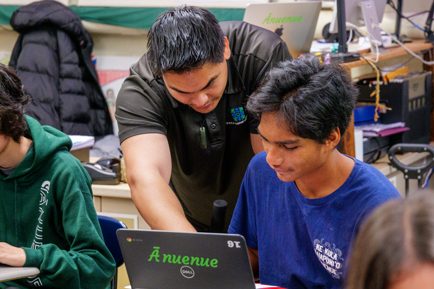 Teacher pointing at student laptop