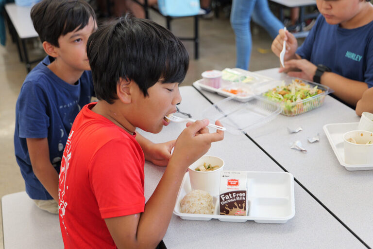 A student eats tofu poke in the Kailua Elementary cafeteria.