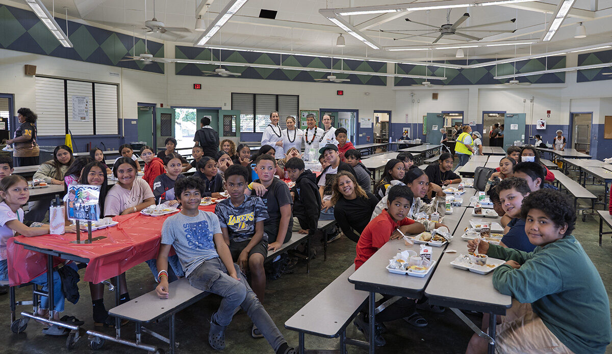 Cafeteria full of students eating lunch.