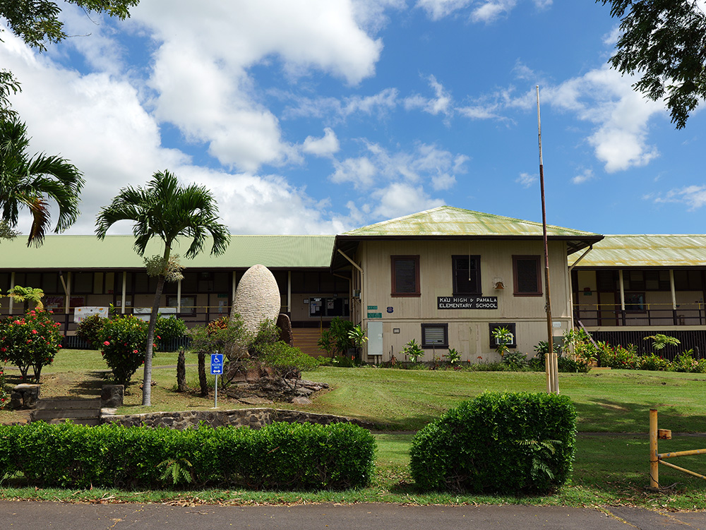 A building on the campus of Ka‘ū High and Pāhala Elementary School with plants in front of it.
