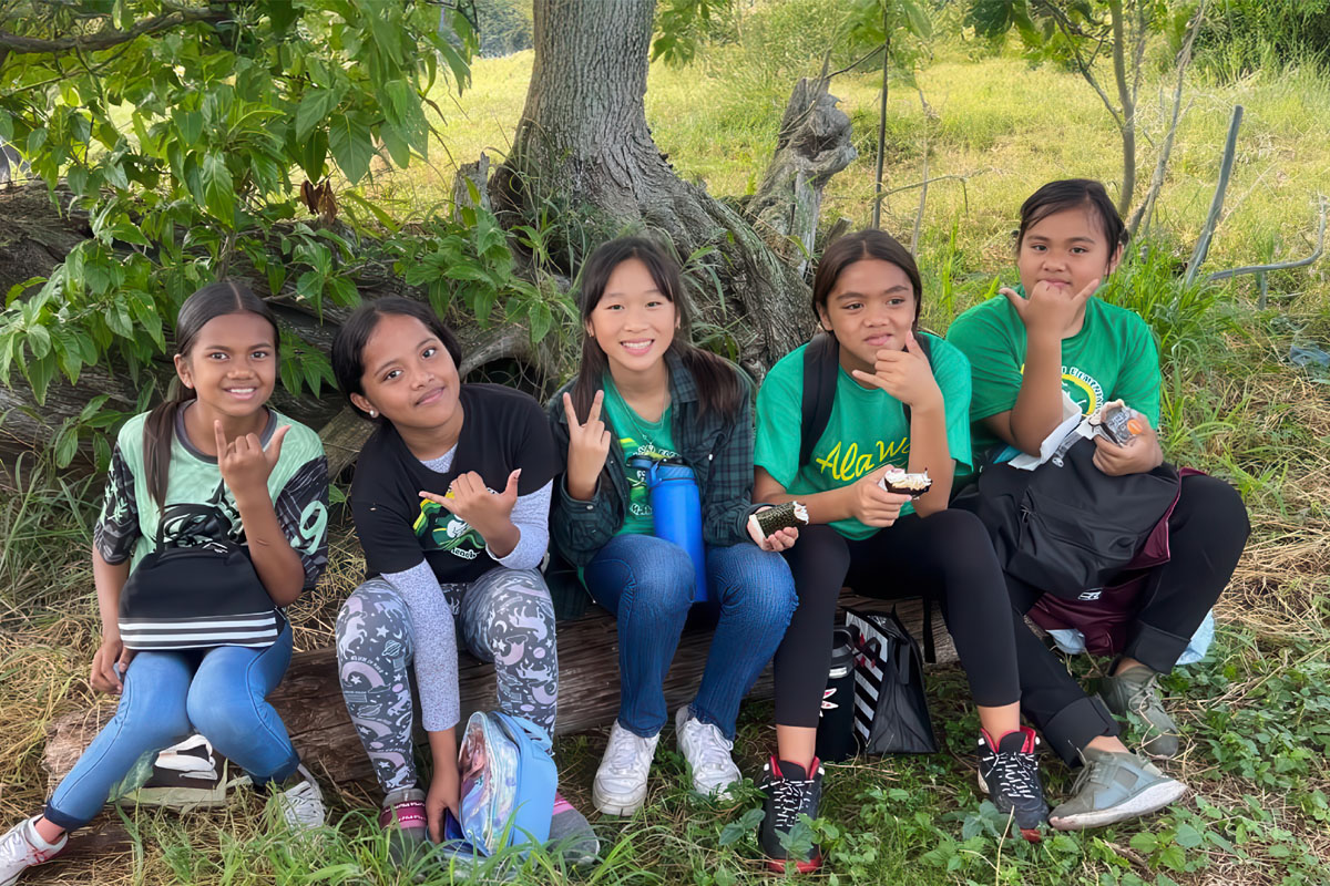Five student sitting in front of a tree