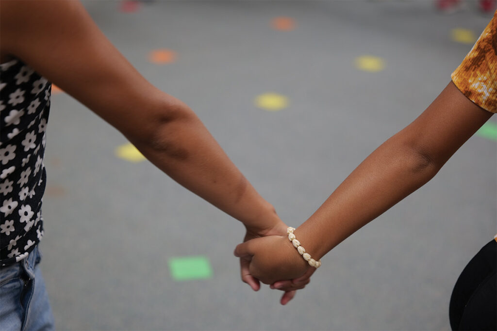 Two students holding hands.