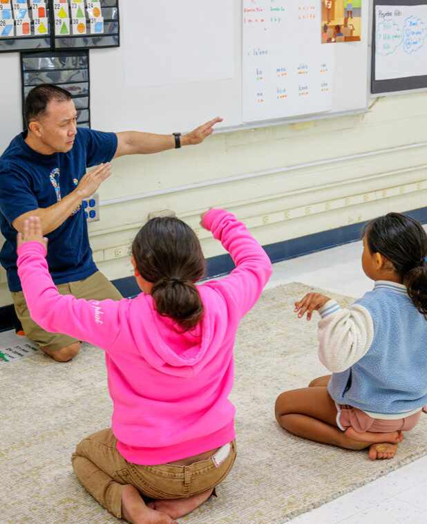 Anuenue teacher and elementary student moving arms