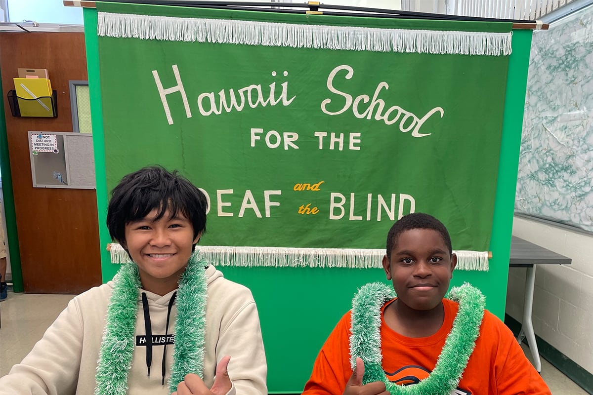 two students in front of a banner