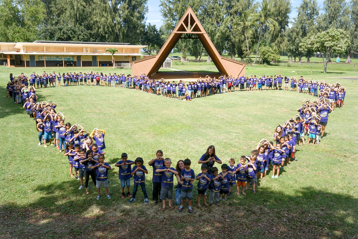 students and staff on grass field