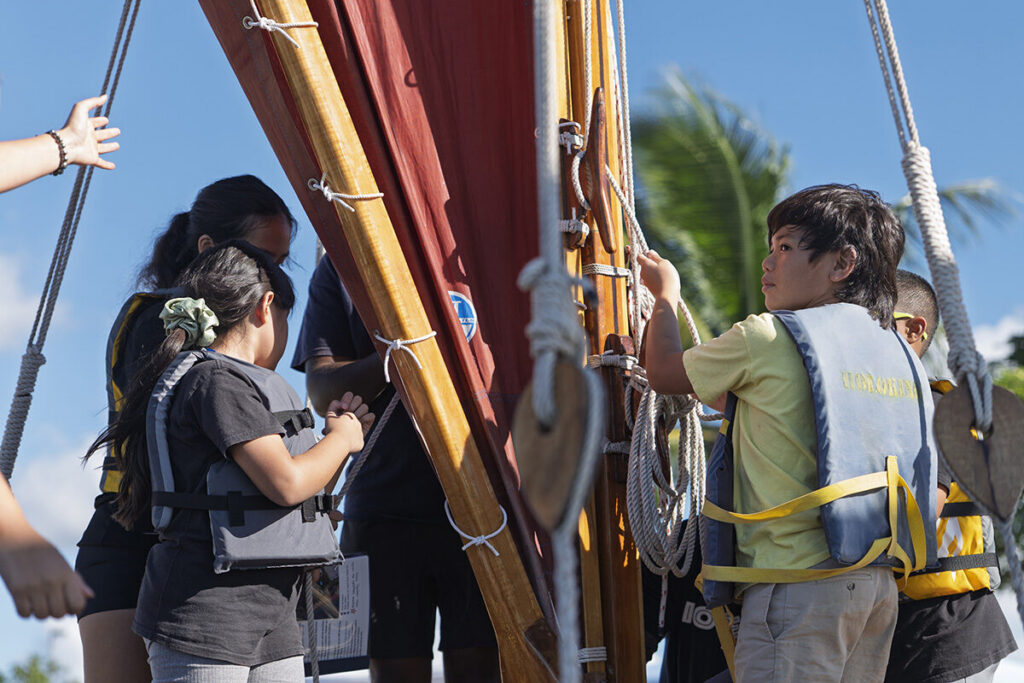 Students stand on a canoe.