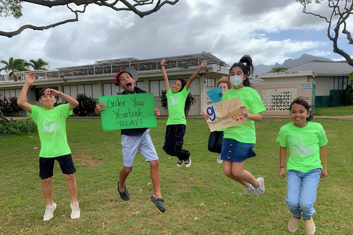 students jumping and holding signs