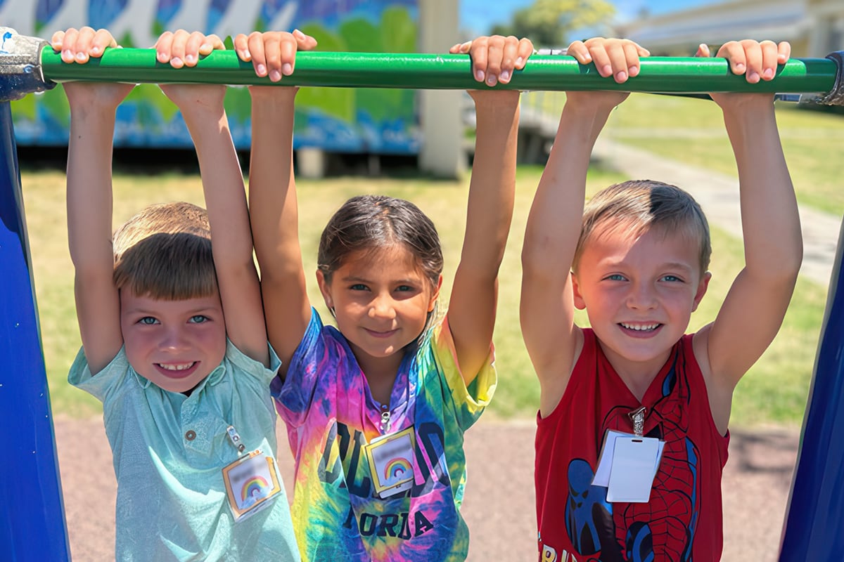 students hanging on pull up bar
