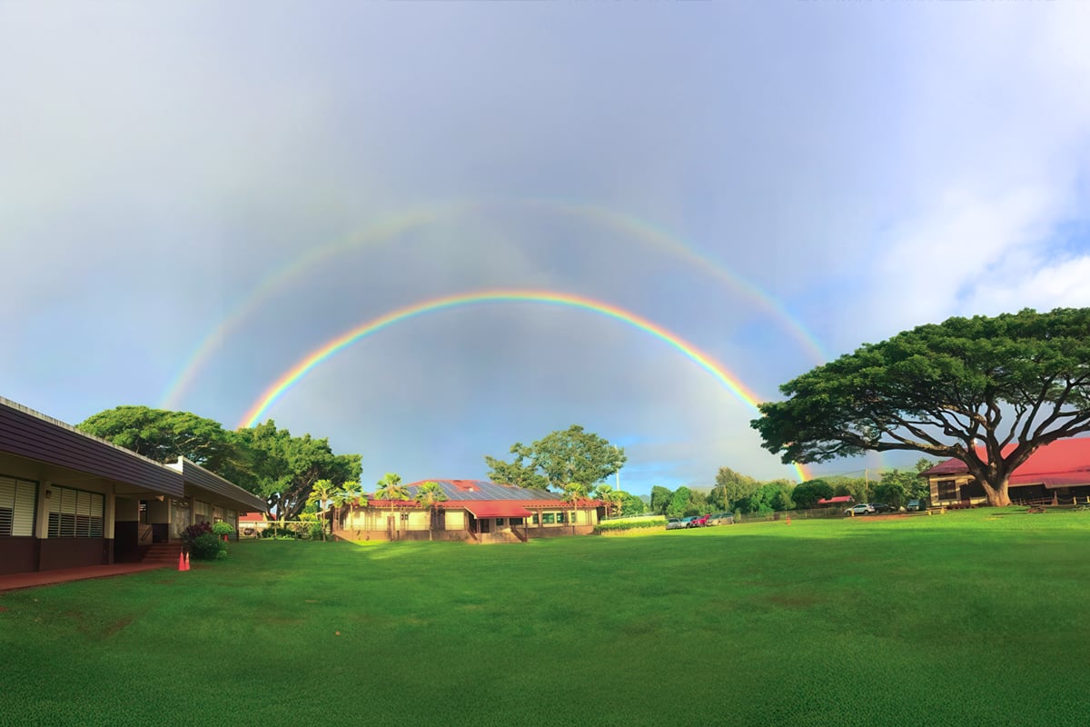 school with a double rainbow in background
