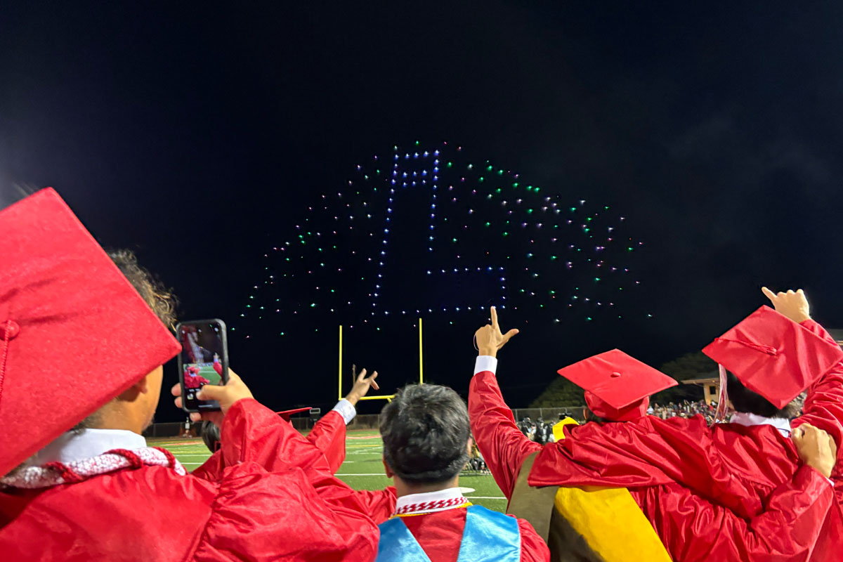 graduates looking at drone show