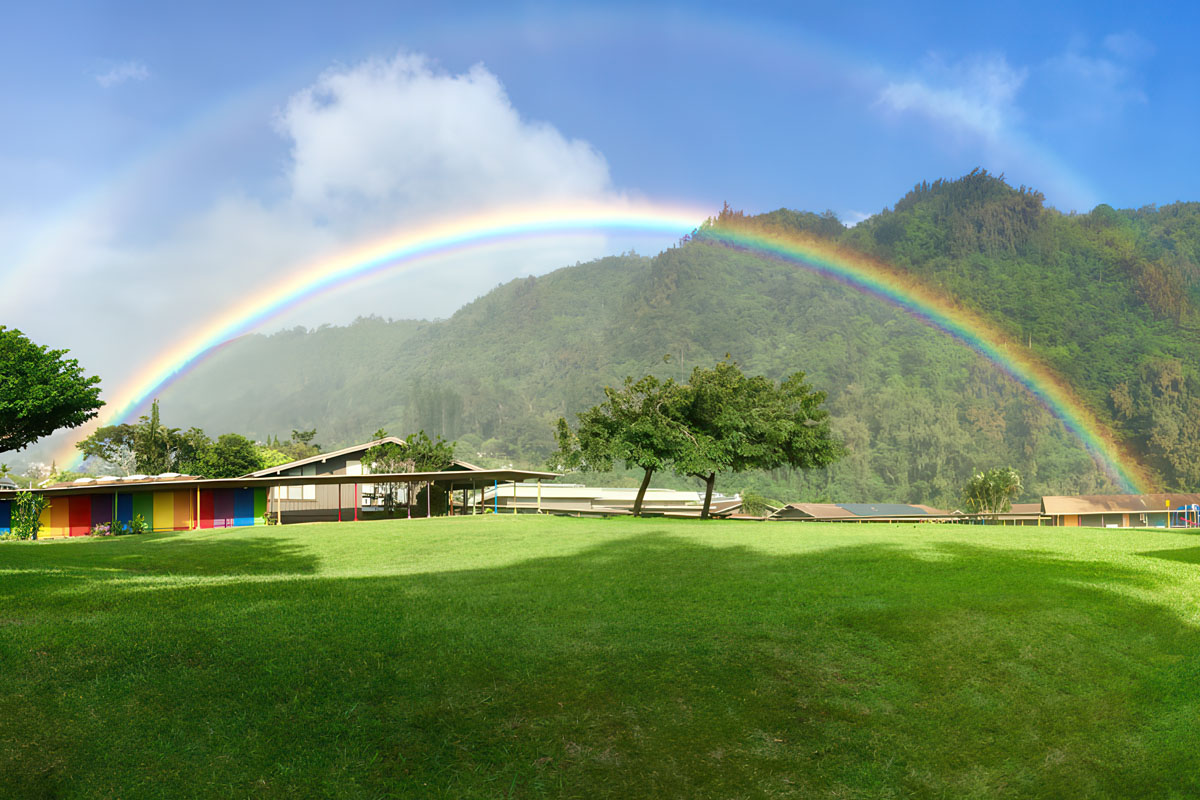 grass field with mountains and a rainbow in the background