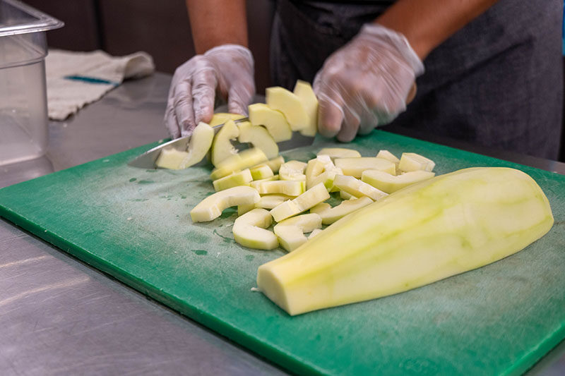 A cook prepares chicken papaya soup.
