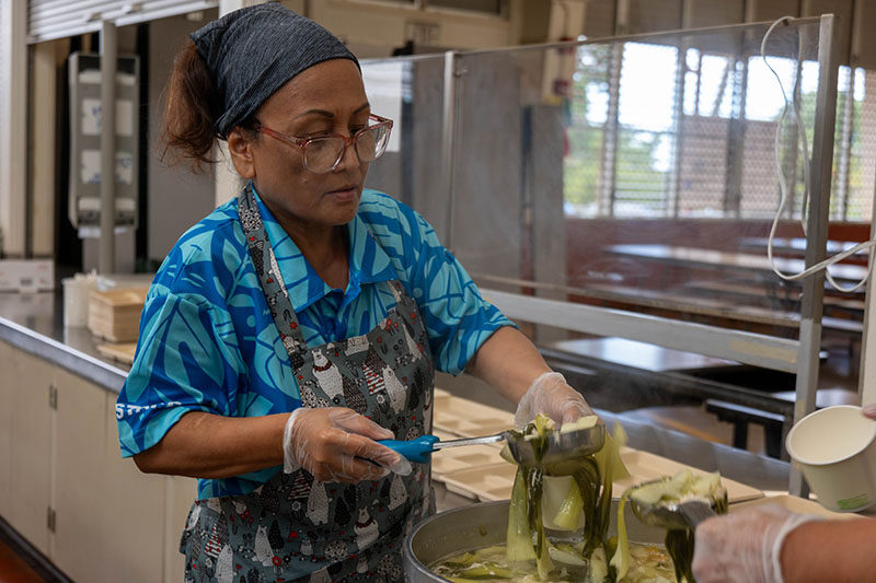 A cook serves chicken papaya soup.