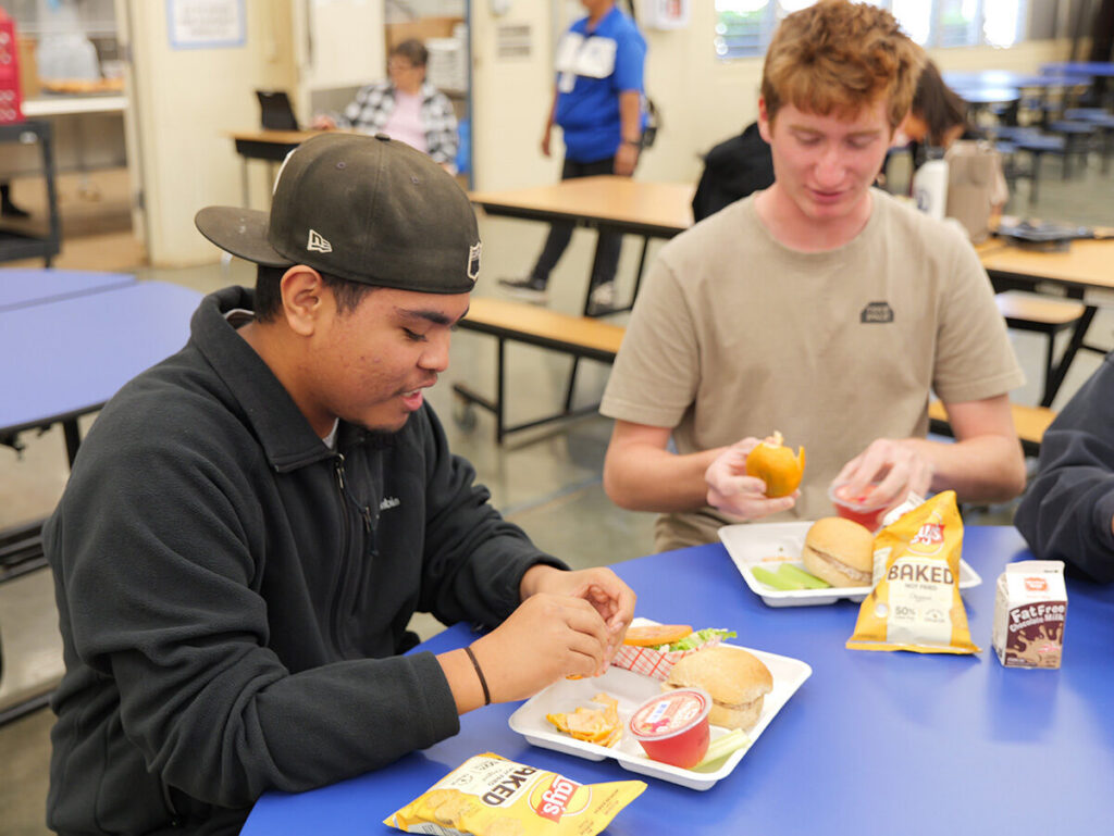 Students at Maui High peel their mandarins served during lunch.