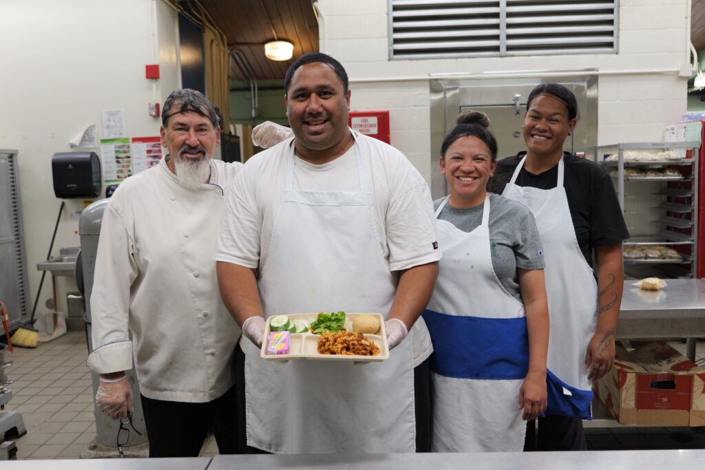 Cafeteria staff holding lunch tray.