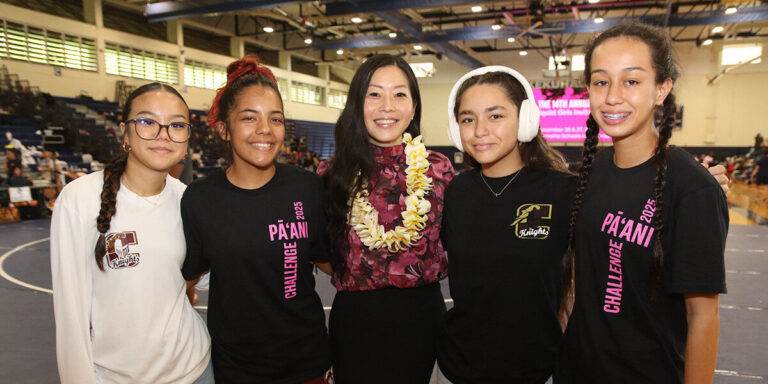 Castle High School wrestlers post with alumni Trisha Nomura.