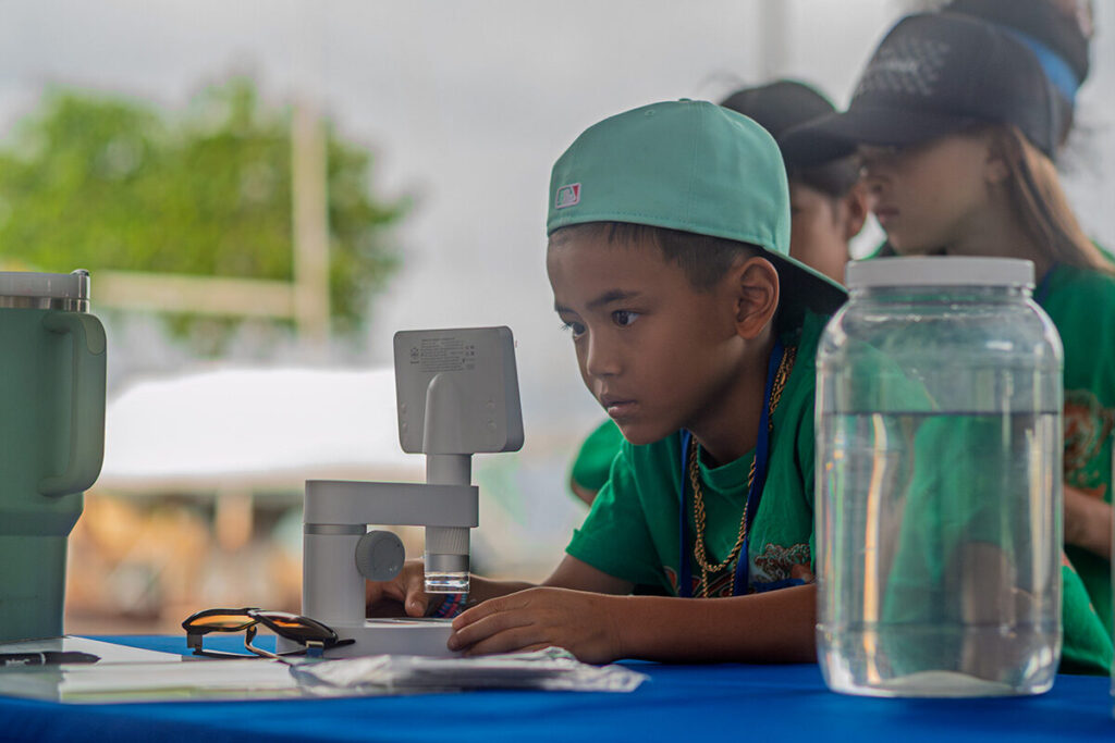 A students look through a microscope.