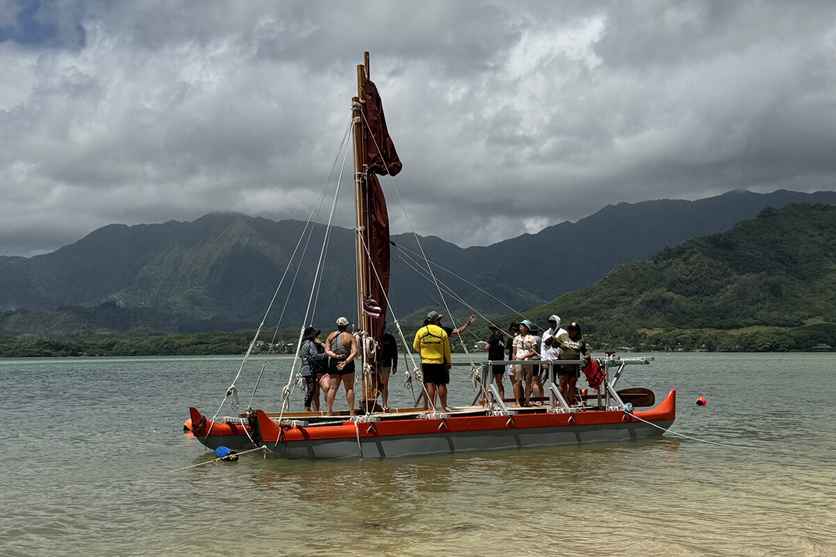 A canoe with teachers sit in the water off Kualoa.